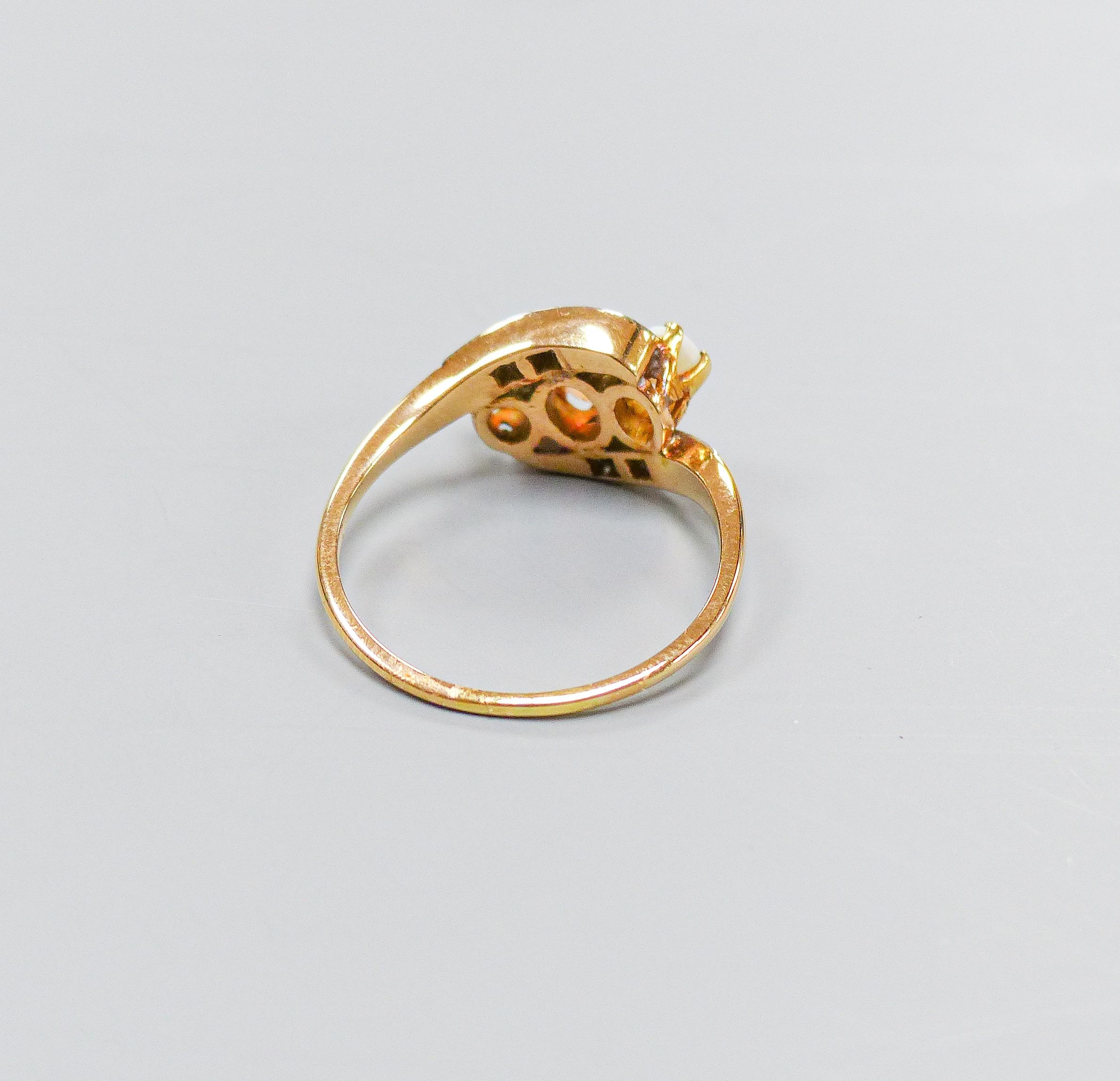 An 18ct and plat, three stone white opal and diamond chip set crossover ring, size S, gross weight 4.1 grams.